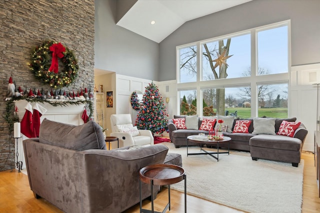 living room featuring light wood-type flooring and high vaulted ceiling