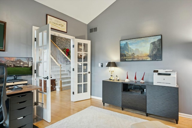 office area with light hardwood / wood-style flooring and high vaulted ceiling