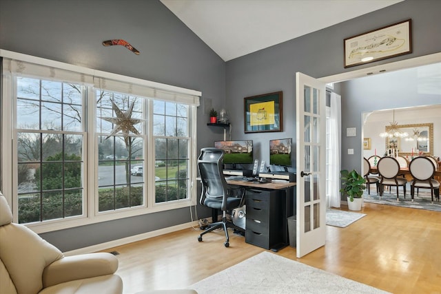 home office with light wood-type flooring, plenty of natural light, and lofted ceiling