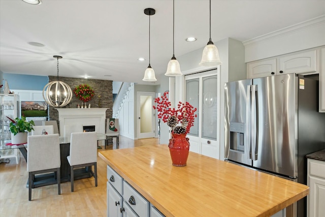 kitchen with white cabinets, stainless steel fridge, light hardwood / wood-style flooring, and butcher block counters