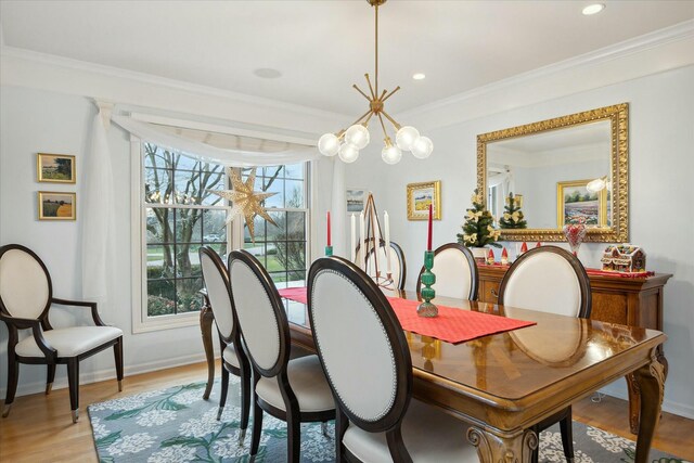 dining area with a notable chandelier, a healthy amount of sunlight, crown molding, and light hardwood / wood-style flooring