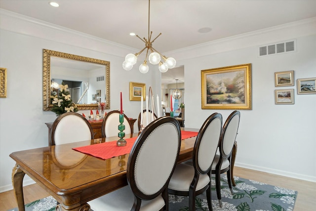 dining space with light hardwood / wood-style flooring, an inviting chandelier, and crown molding