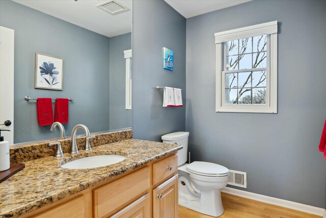 bathroom with vanity, wood-type flooring, and toilet