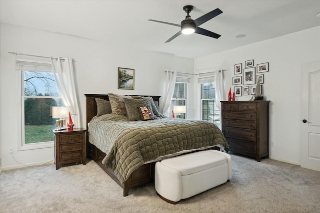 bedroom with ceiling fan and light colored carpet