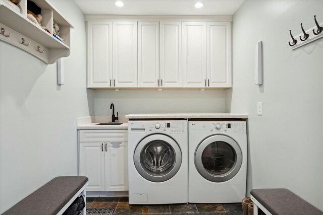 laundry area featuring cabinets, separate washer and dryer, and sink