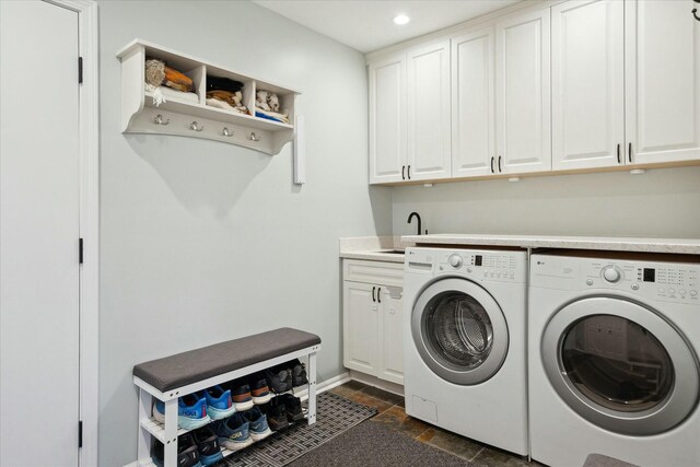 laundry area featuring cabinets, separate washer and dryer, and sink