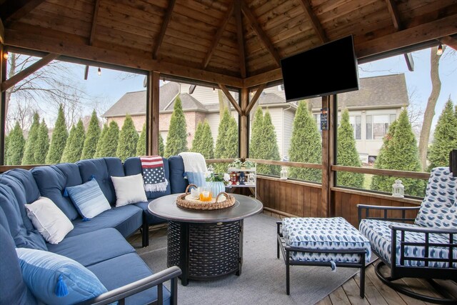 sunroom / solarium with vaulted ceiling with beams, plenty of natural light, and wooden ceiling