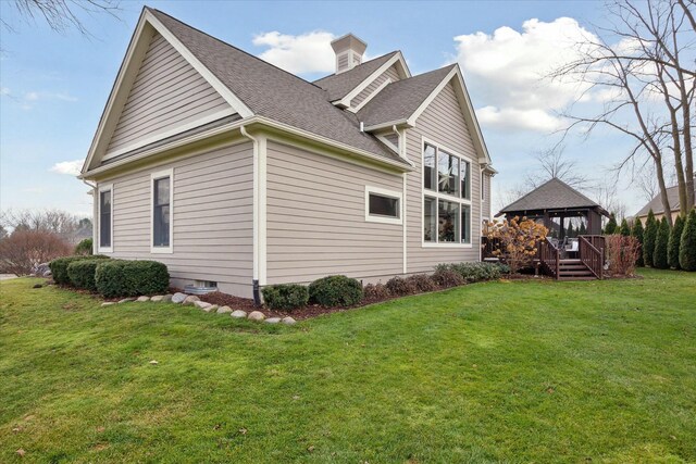 view of side of home featuring a gazebo and a lawn