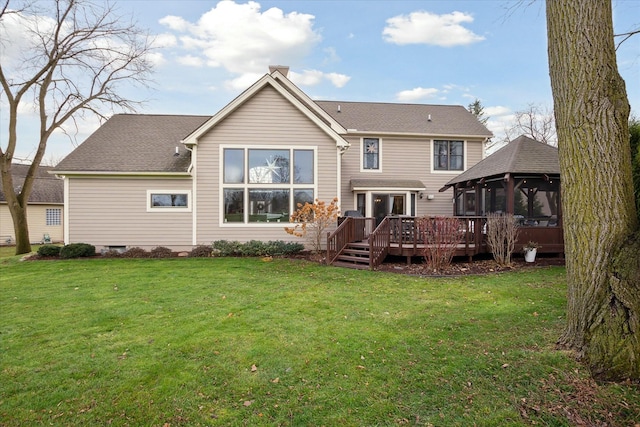 back of house with a sunroom, a deck, and a yard