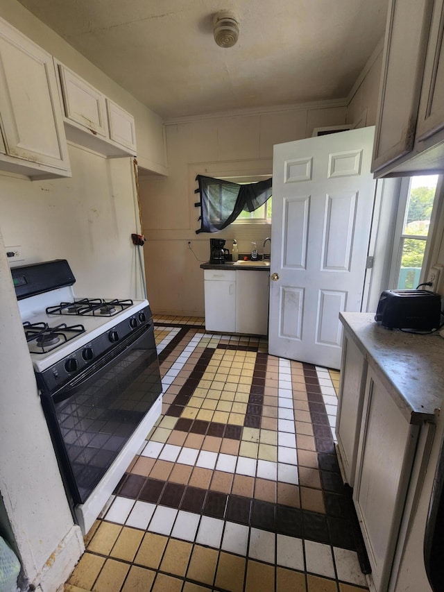 kitchen featuring white appliances, dark tile patterned flooring, and sink