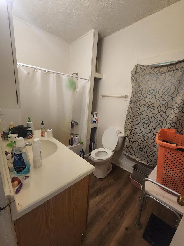 bathroom with vanity, wood-type flooring, a textured ceiling, and toilet