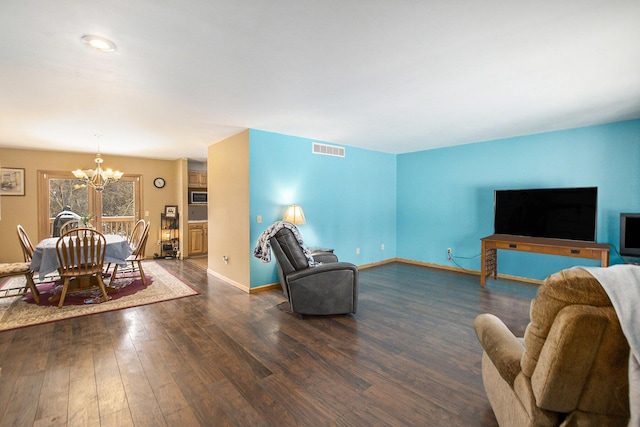 living room with dark hardwood / wood-style flooring and a notable chandelier