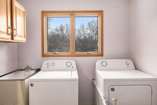 laundry area featuring washer and dryer and cabinets