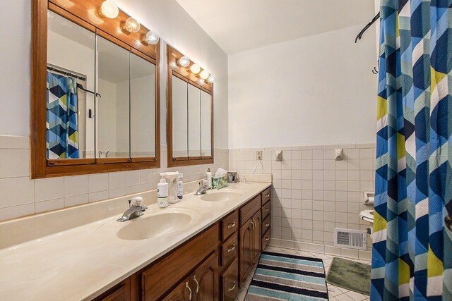 bathroom with tile patterned floors, vanity, and tile walls