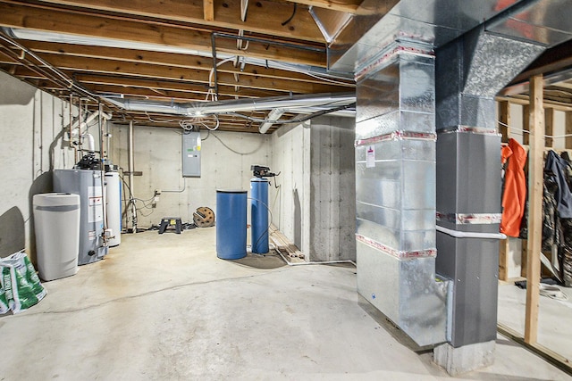 basement featuring electric panel, heating unit, and gas water heater