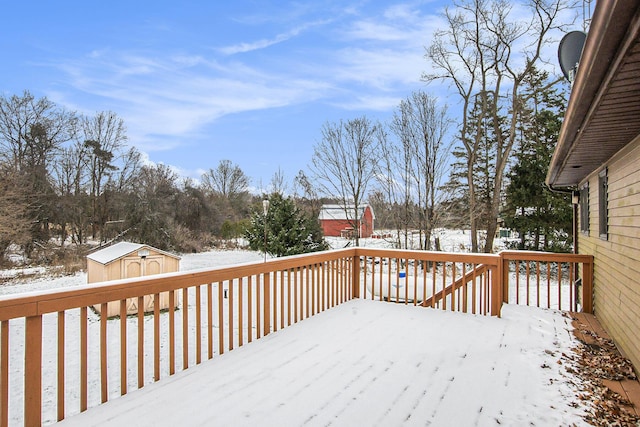 snow covered deck with a storage shed