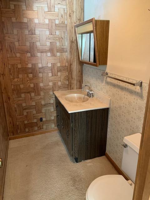 bathroom featuring parquet floors, vanity, and toilet