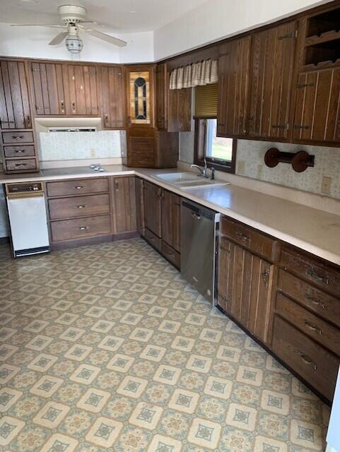 kitchen with dark brown cabinetry, ceiling fan, dishwasher, and sink