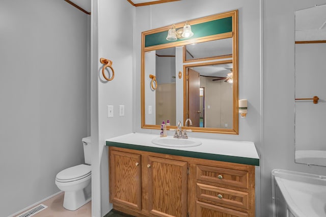 bathroom with vanity, toilet, ceiling fan, and crown molding