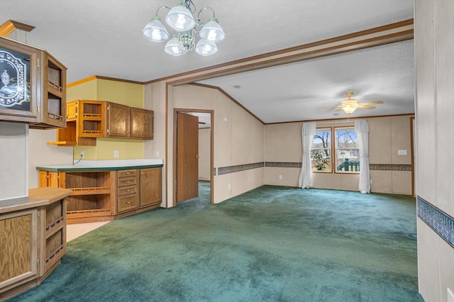 kitchen featuring pendant lighting, dark carpet, ornamental molding, and a textured ceiling