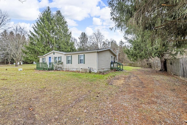 manufactured / mobile home with a wooden deck and a front yard