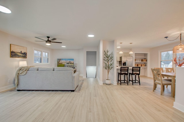 living room featuring light hardwood / wood-style floors and ceiling fan