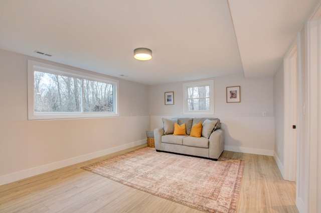 living area with hardwood / wood-style floors and a healthy amount of sunlight