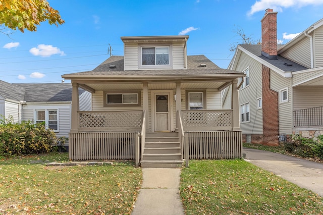 bungalow featuring a porch and a front lawn