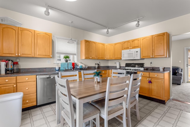 kitchen featuring sink, rail lighting, hanging light fixtures, and white appliances