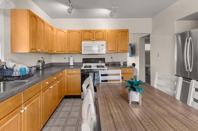 kitchen with sink, white appliances, and rail lighting