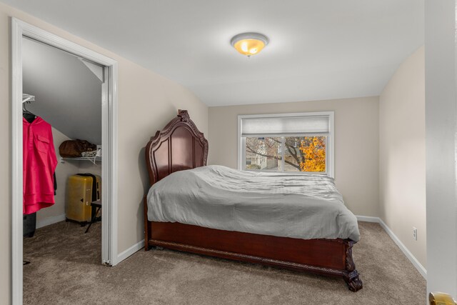 bedroom with light colored carpet, a closet, and lofted ceiling