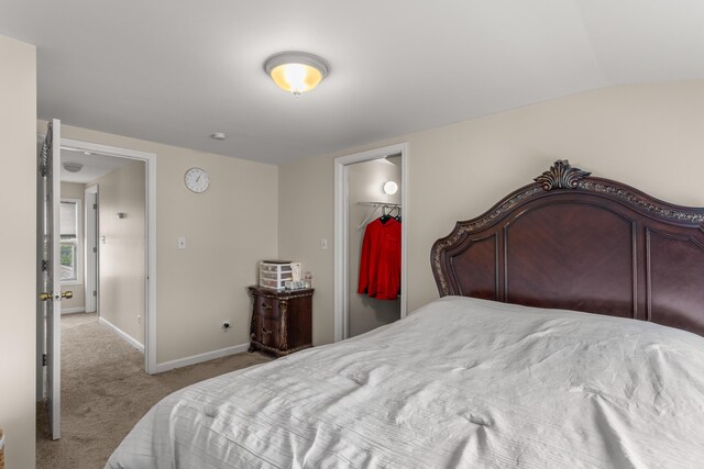 bedroom with lofted ceiling, light colored carpet, a spacious closet, and a closet