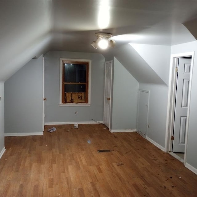 additional living space with lofted ceiling and light hardwood / wood-style flooring