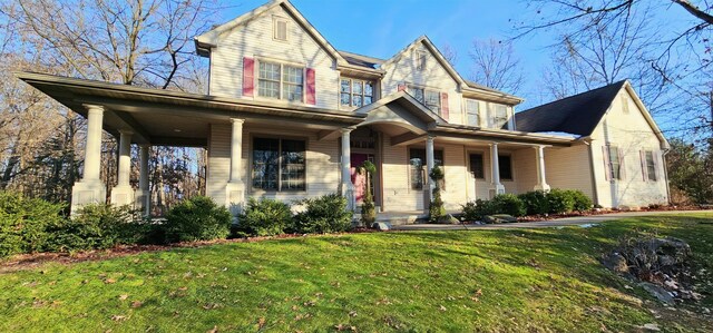 view of front of property featuring covered porch and a front yard