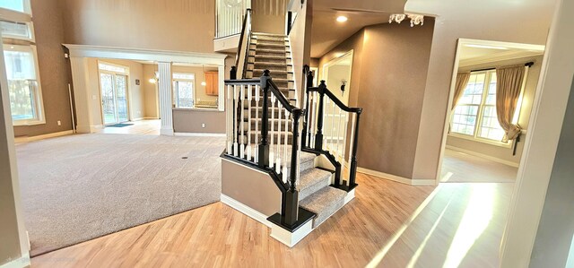 stairway with ornate columns, ornamental molding, and hardwood / wood-style flooring