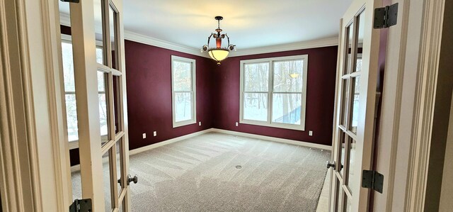 unfurnished room with light colored carpet, crown molding, and french doors