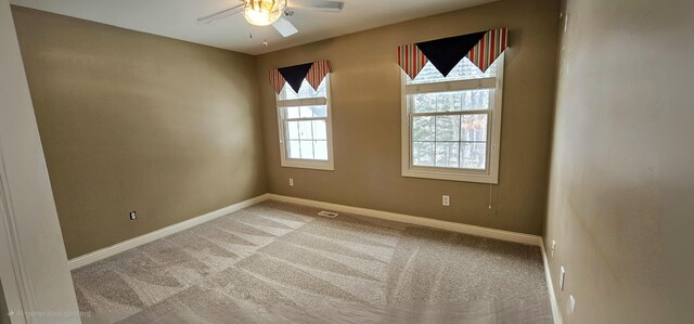 carpeted spare room featuring ceiling fan