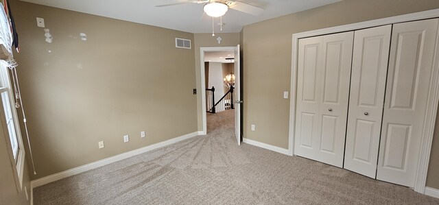 unfurnished bedroom with ceiling fan, a closet, and light colored carpet