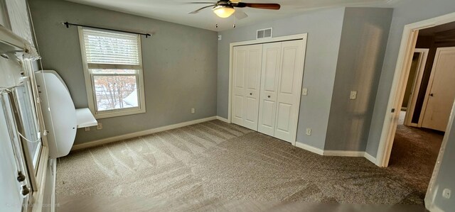 unfurnished bedroom with carpet floors, a closet, and ceiling fan