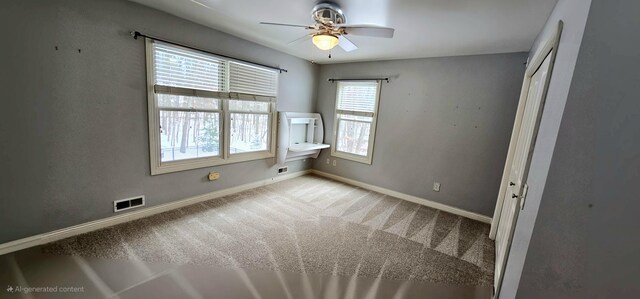 spare room featuring ceiling fan and light colored carpet