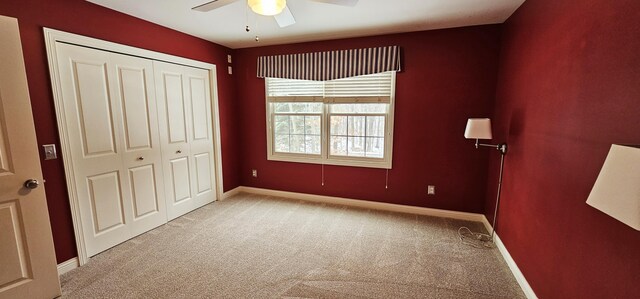 unfurnished bedroom with ceiling fan, a closet, and light carpet