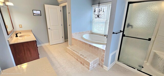 bathroom featuring tile patterned floors, vanity, separate shower and tub, and an inviting chandelier