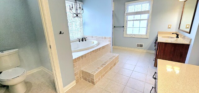 bathroom with tile patterned floors, vanity, a relaxing tiled tub, an inviting chandelier, and toilet