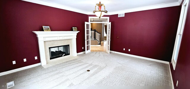 unfurnished living room with light colored carpet, ornamental molding, and a tiled fireplace