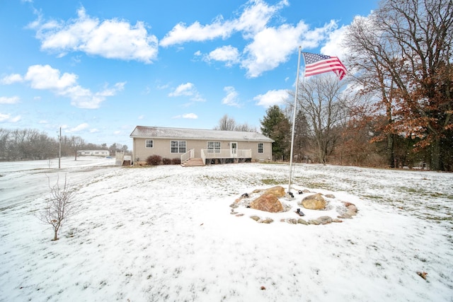 snow covered property with a wooden deck