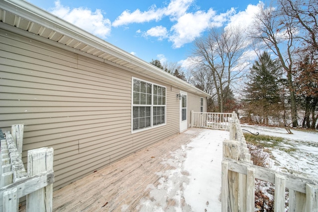 snow covered patio with a wooden deck