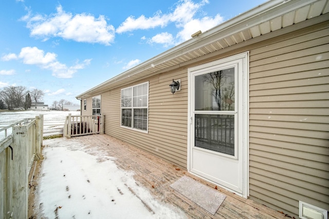 snow covered patio with a deck