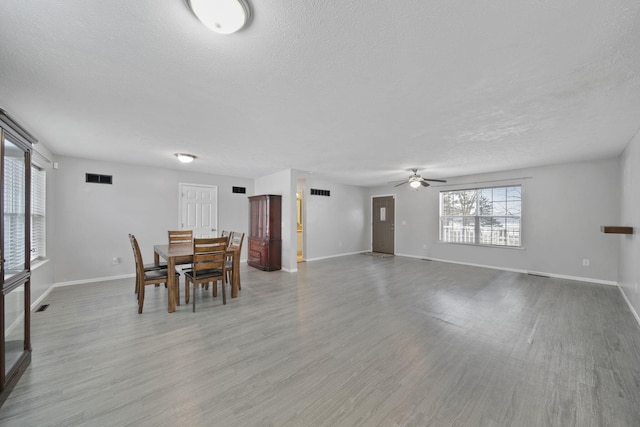 dining space with ceiling fan, a textured ceiling, and light hardwood / wood-style flooring