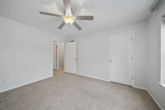 spare room featuring ceiling fan and light carpet