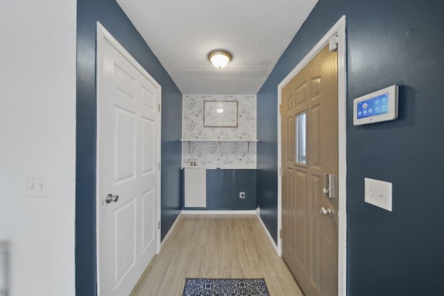 entryway featuring a textured ceiling and light hardwood / wood-style flooring